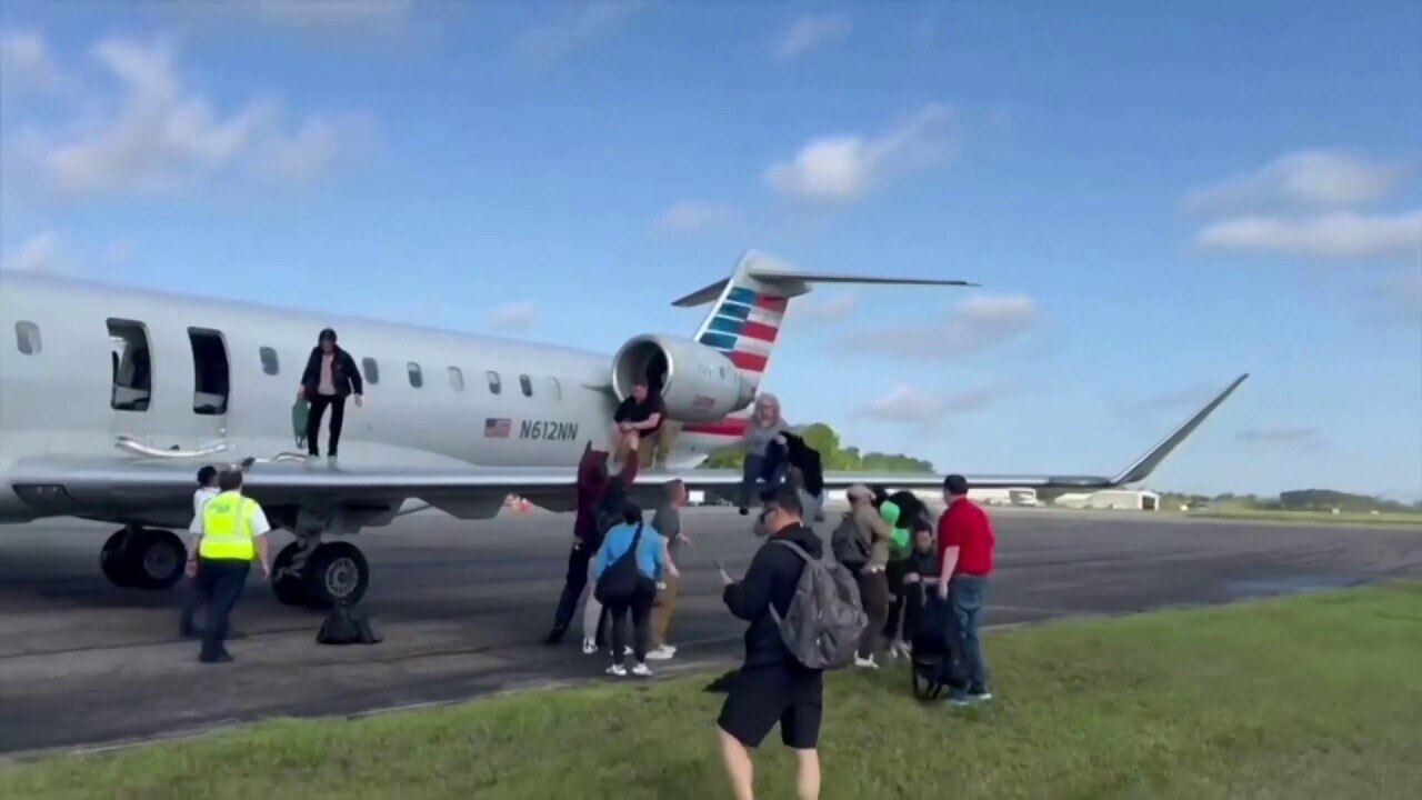 American Airlines passengers evacuate on plane's wing after landing