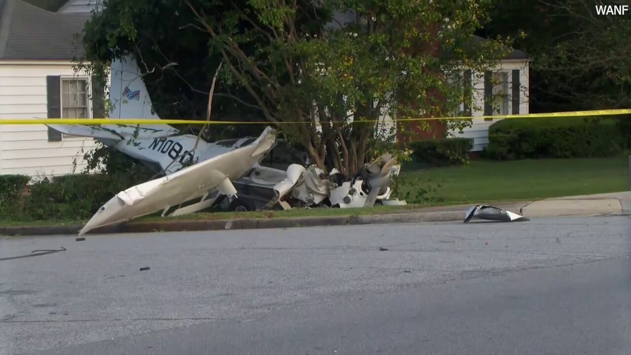 Plane wreckage lodged in tree after aircraft crashes into front yard