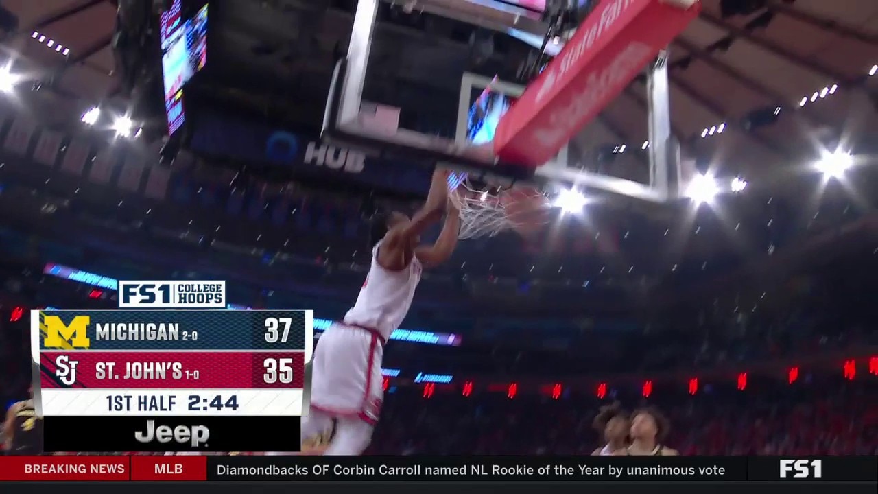 St. John’s Jordan Dingle slams a two-handed dunk to trim Michigan’s lead to two points