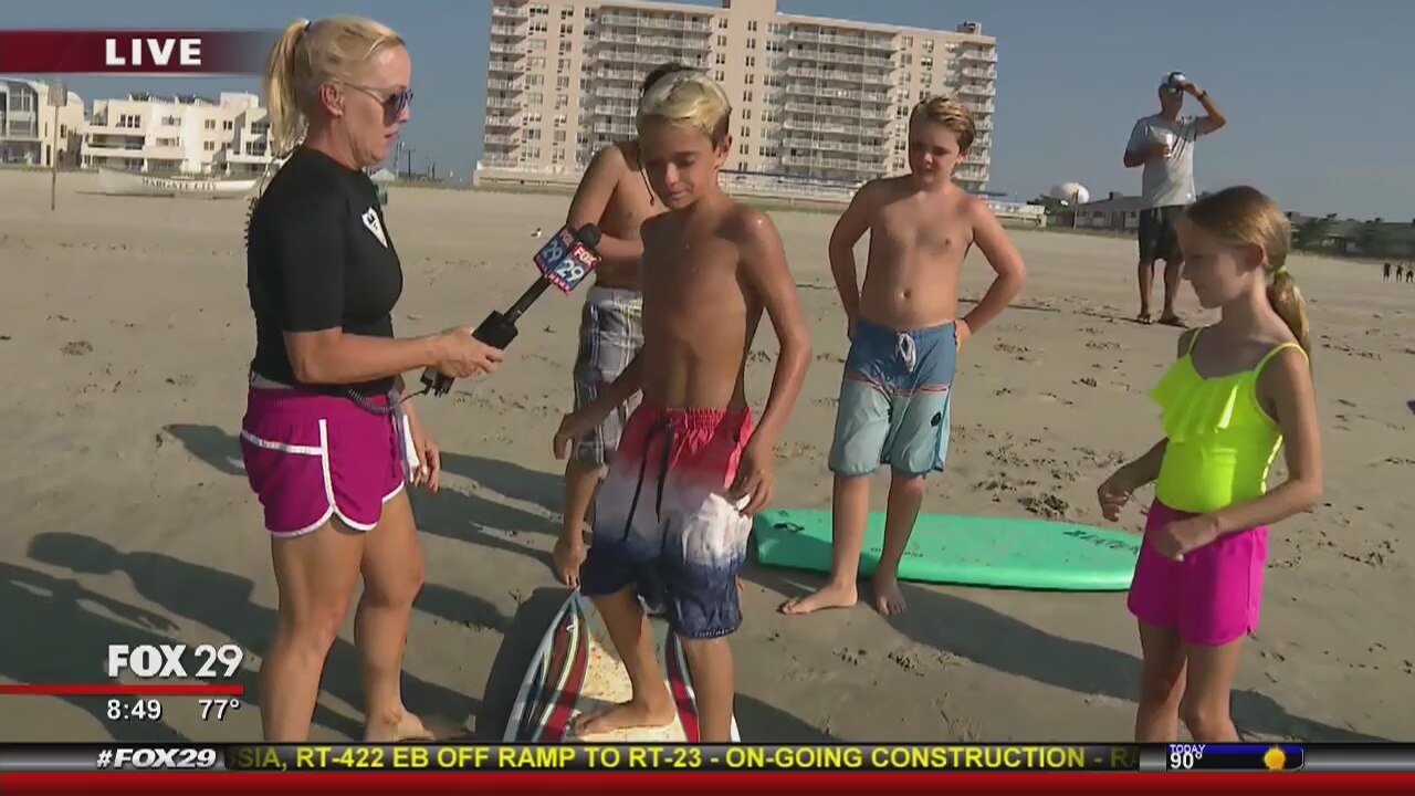 Jenn learns how to surf from some experts
