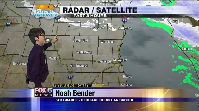 Noah Bender helps Meteorologist Rob Haswell with the weather