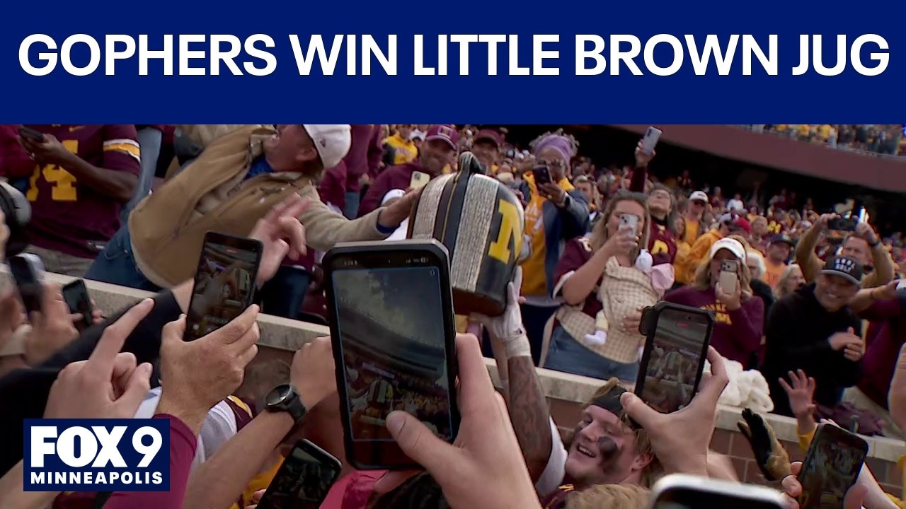 Gophers celebrate with Little Brown Jug after beating Michigan, 20-14