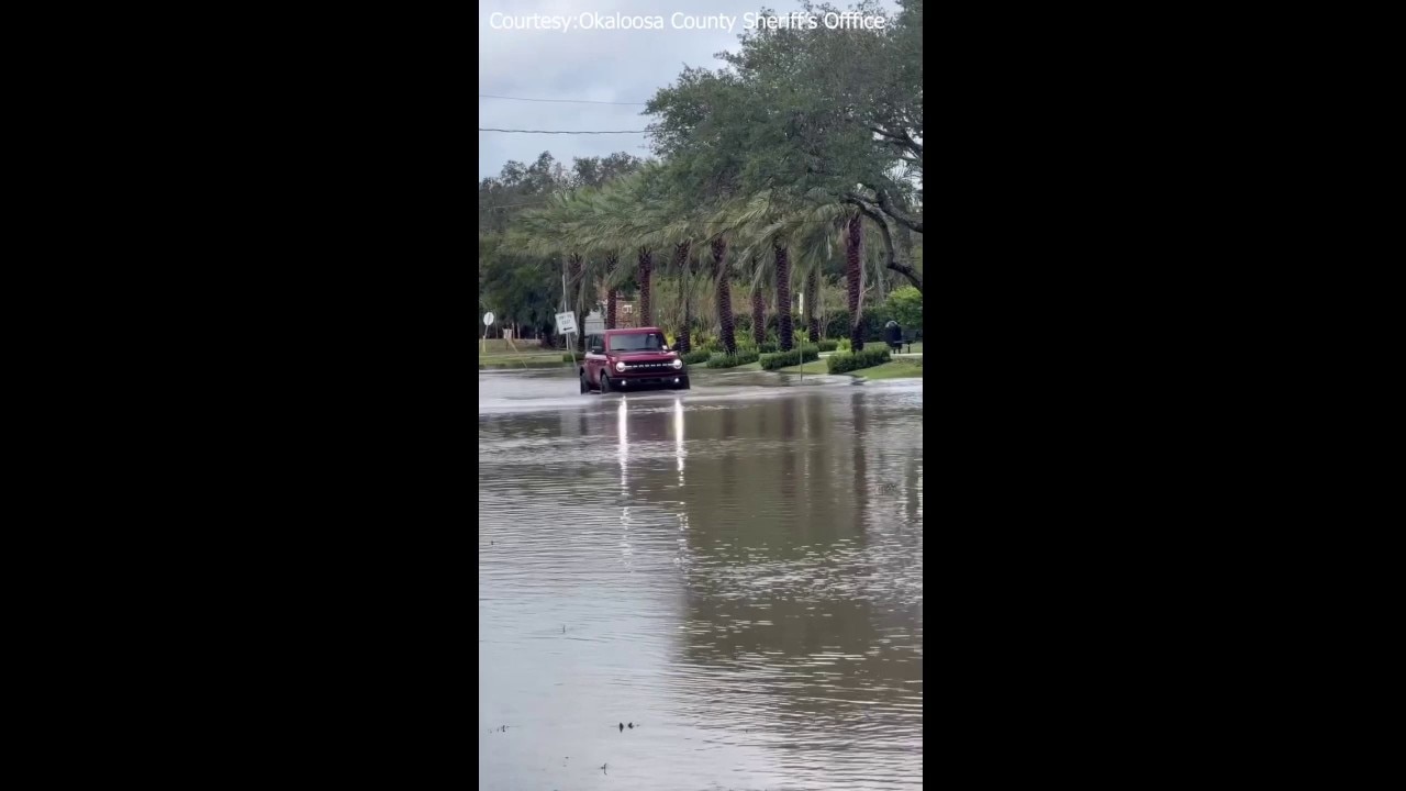 Car drives through floodwaters in Destin