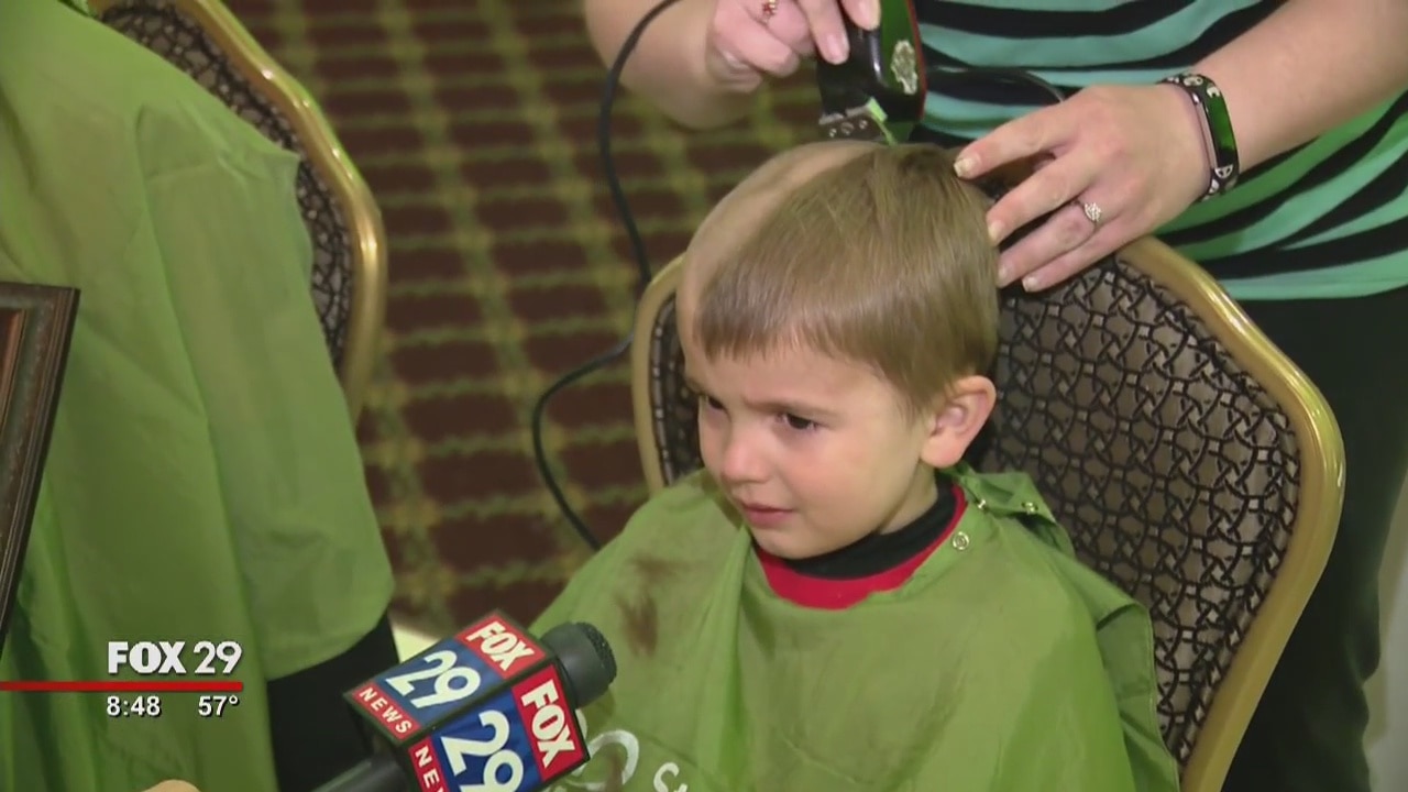 Volunteers shave their heads in solidarity with childhood cancer victims