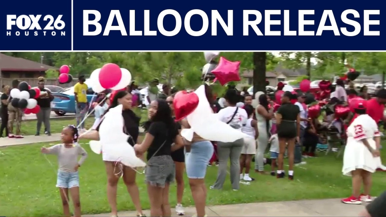 Family holding balloon release for shooting victim