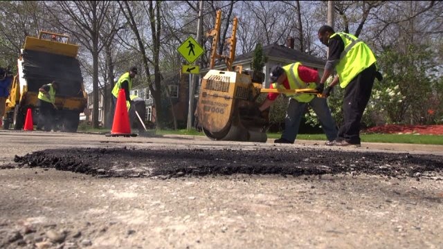 20 new employees get to work filling potholes
