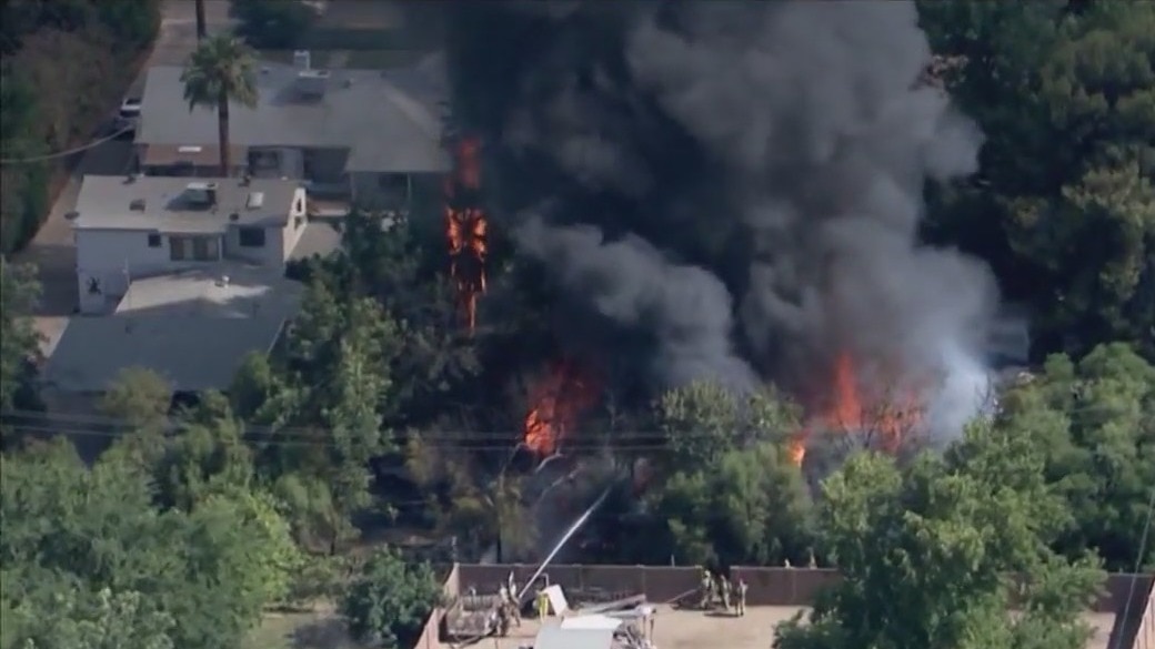 Crews battle fire involving trees, structures