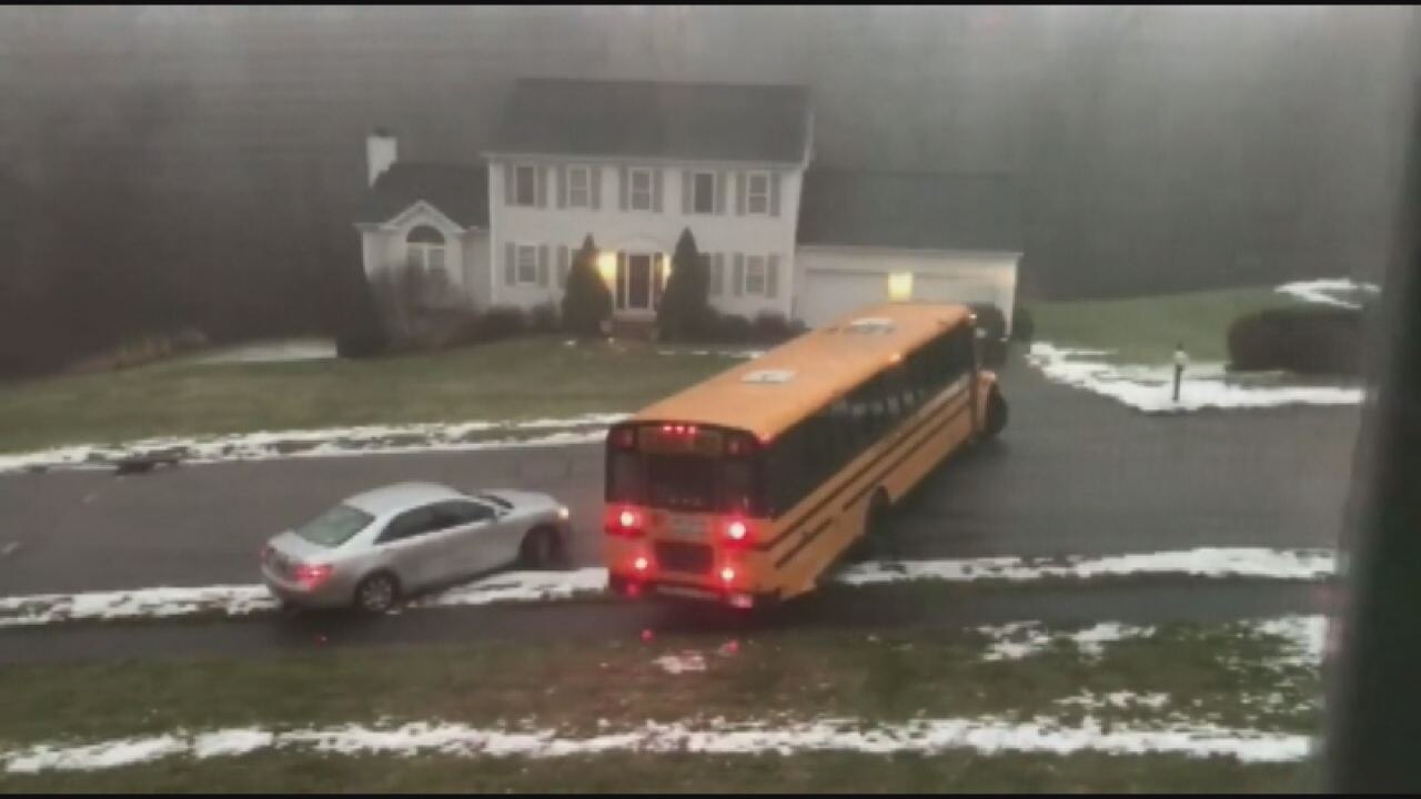 School bus filled with students slides down icy street