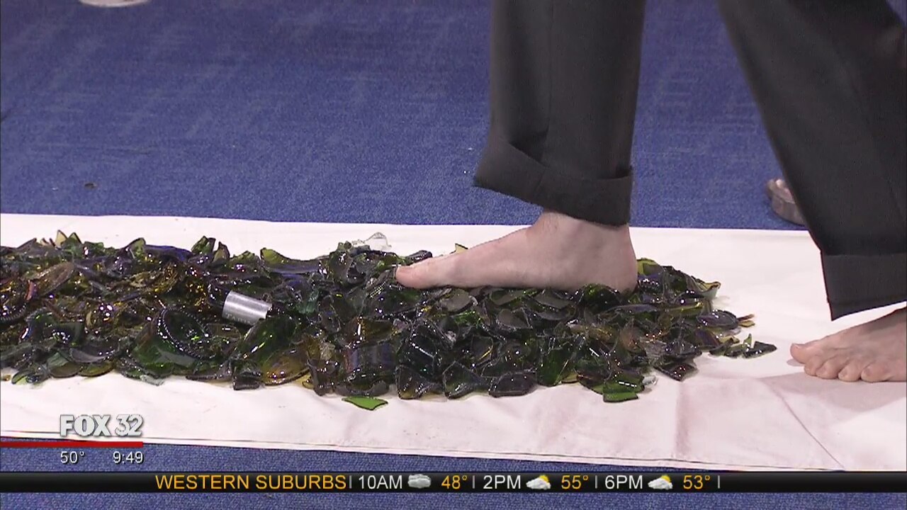 Dennis Watkins walks on broken glass without a scratch