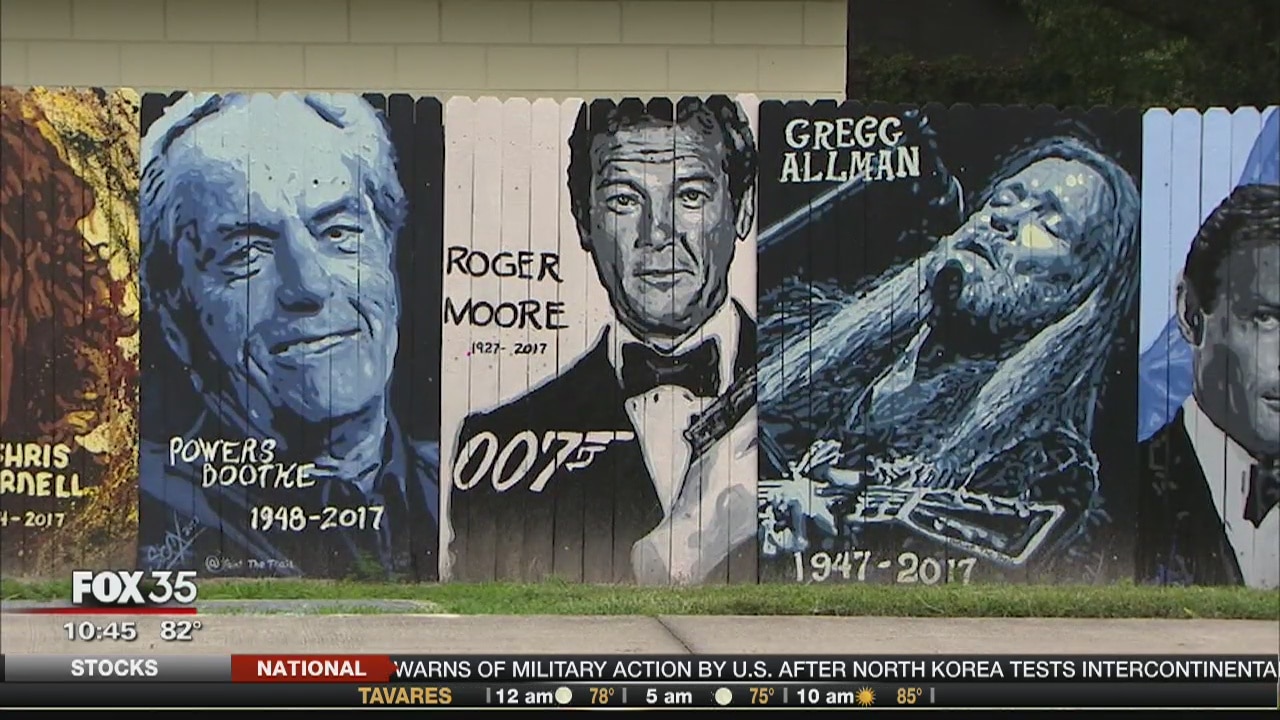 Pop up artist paints famous faces on fences
