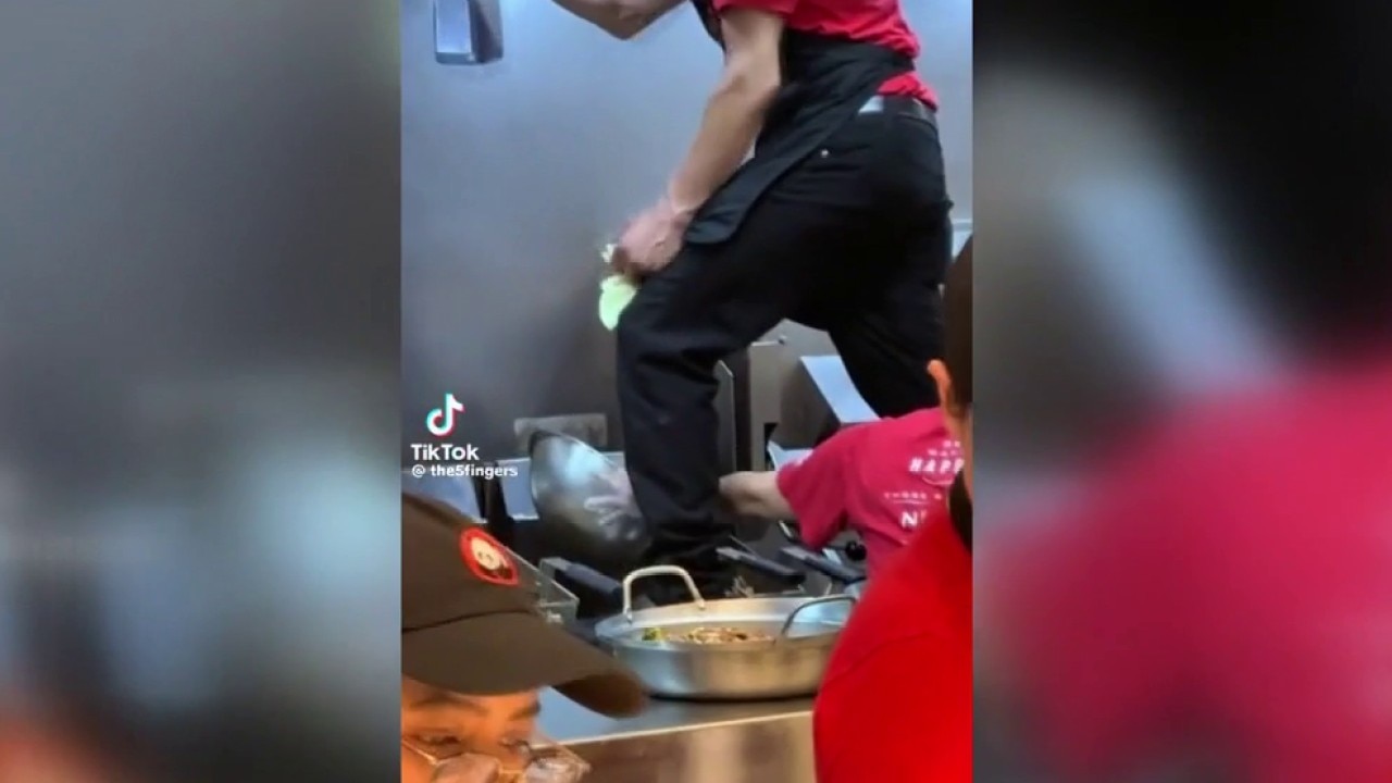 Panda Express employee stands on fryer