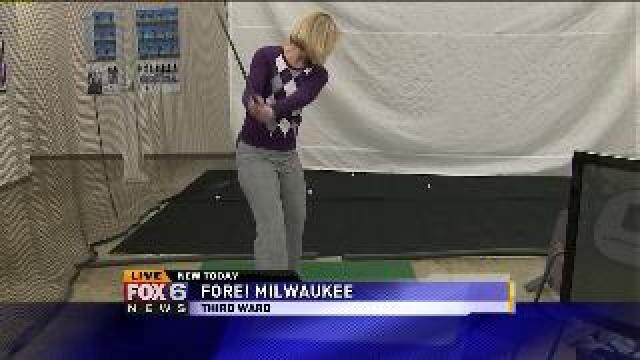 Laura works on her golf game at Fore! Milwaukee