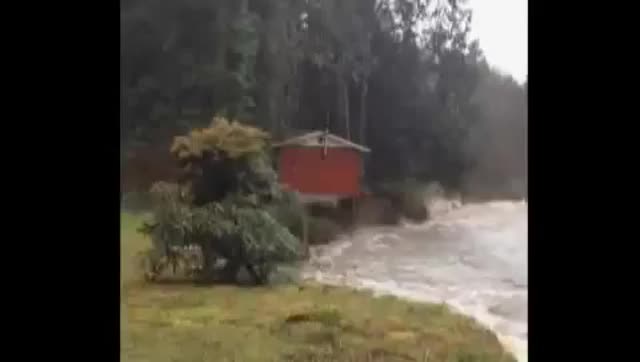 RAW VIDEO: House falls into river, floats down stream