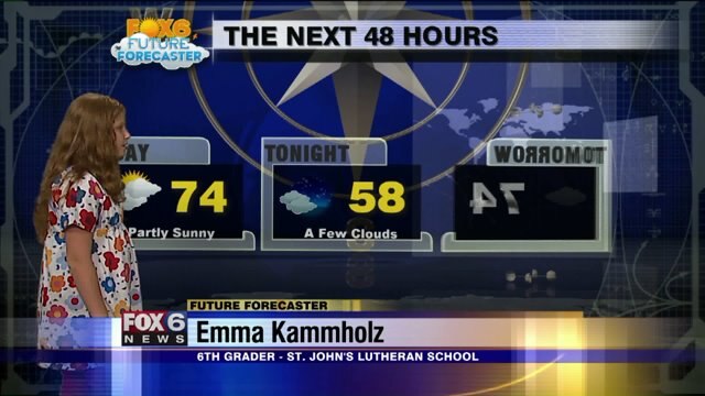 Emma Kammholz helps Meteorologist Rob Haswell with the weather