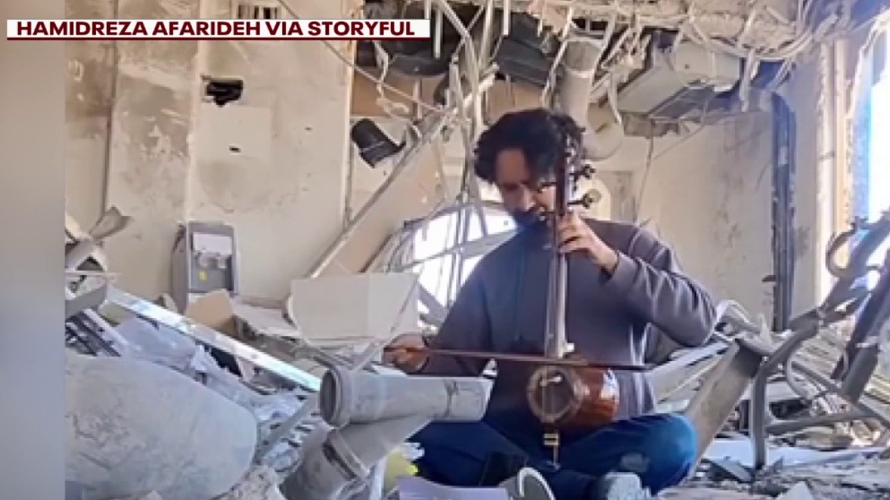 Teacher plays music at site of destroyed school in Iran