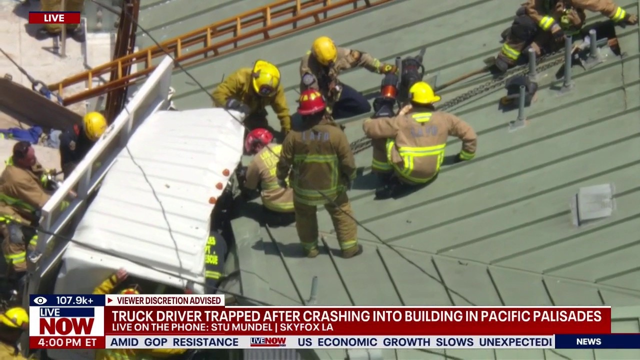 Driver rescued after truck crashes into building