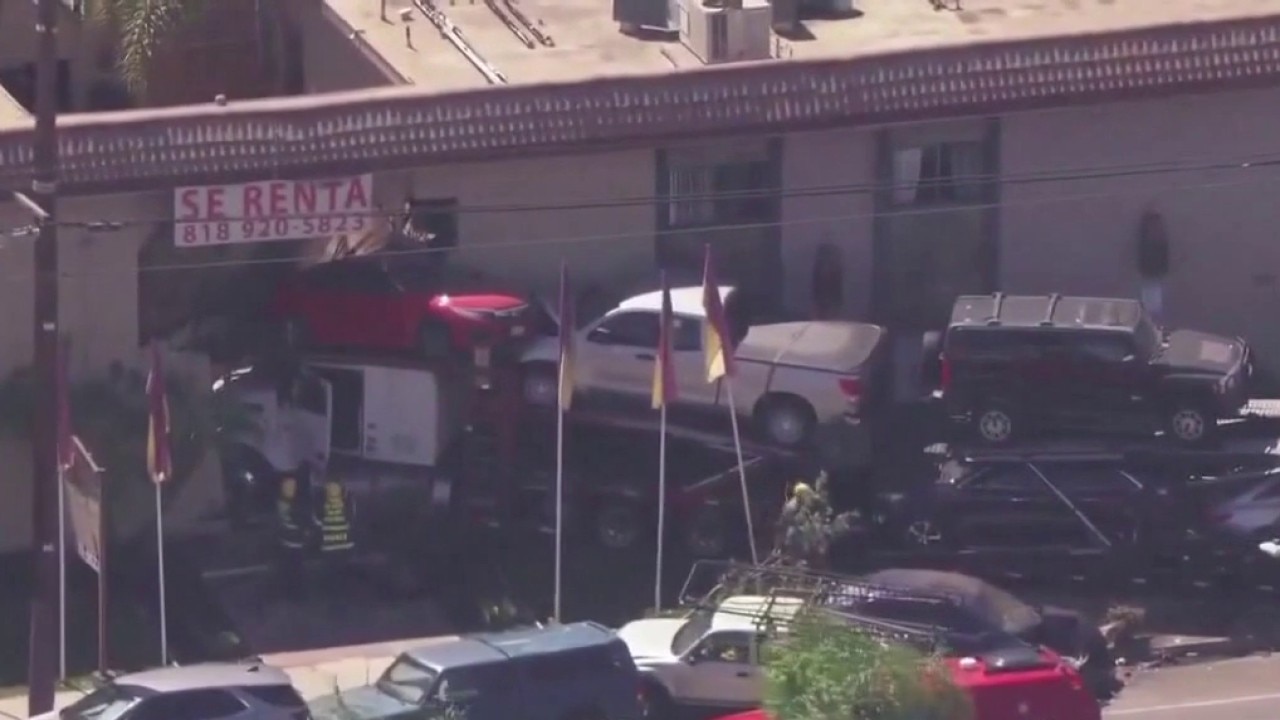 Car-hauling truck slams into apartment building