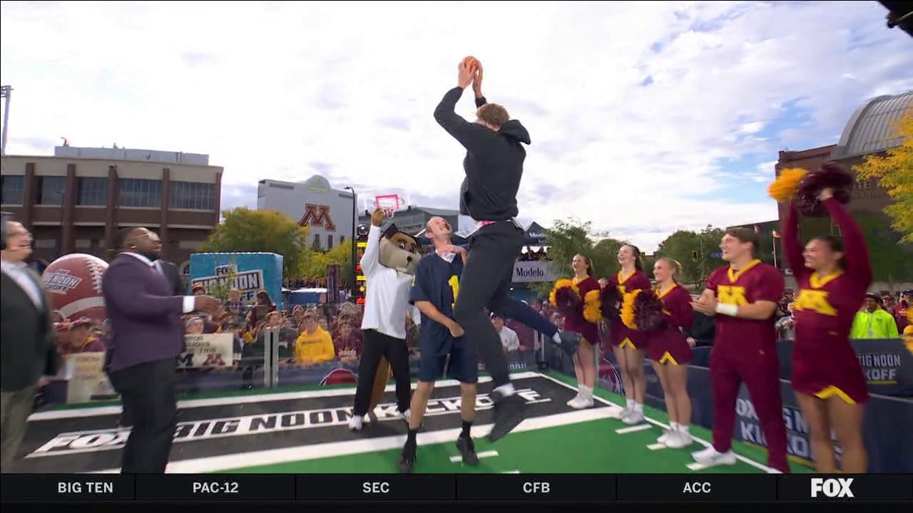 Gophers basketball player Malick Kordel dunks on Michigan fan