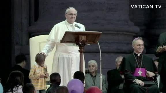 Child hugs Pope Francis on stage