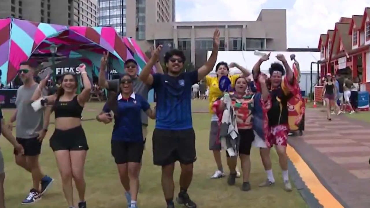 Roaring crowds in the afternoon wave at the FIFA Fan Festival
