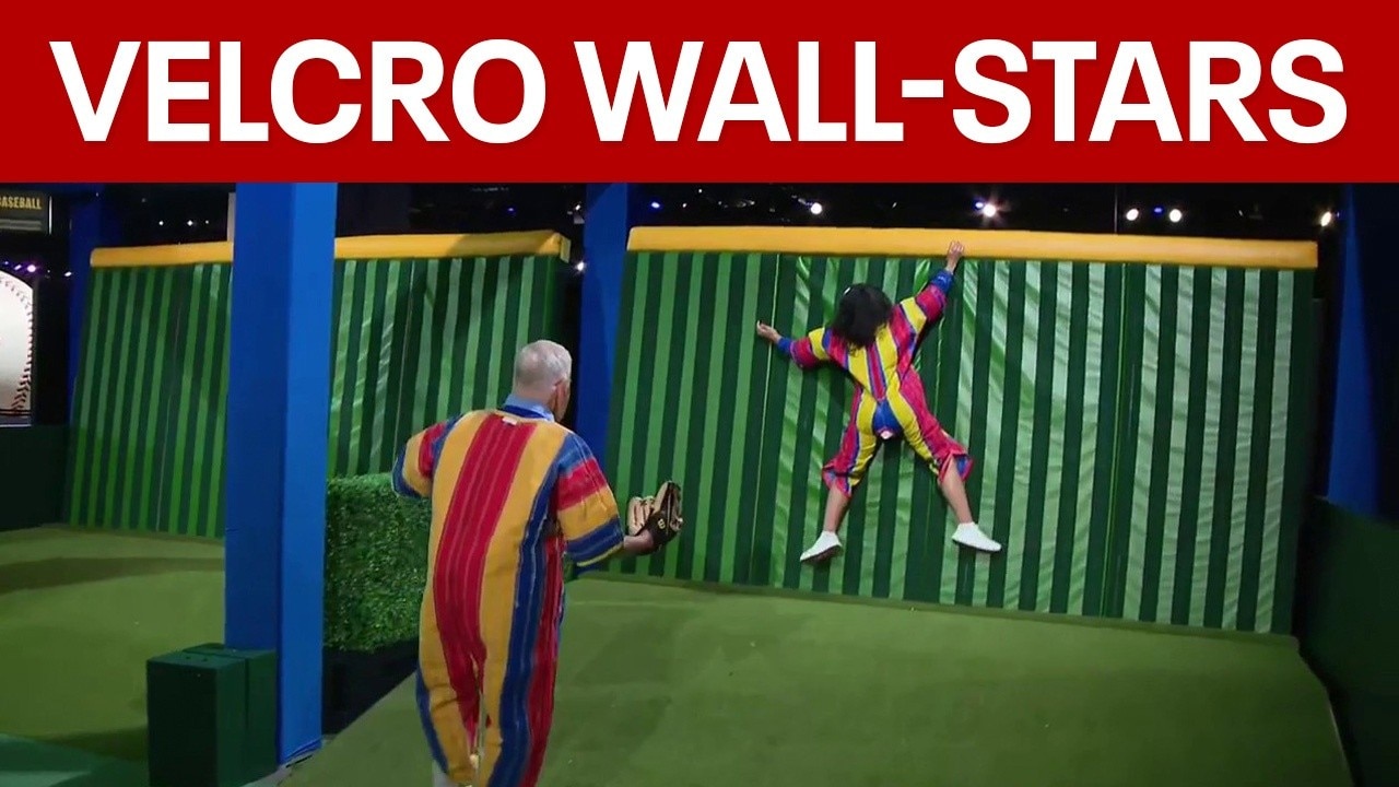 Alex and Mike try the velcro wall at MLB All-Star Village