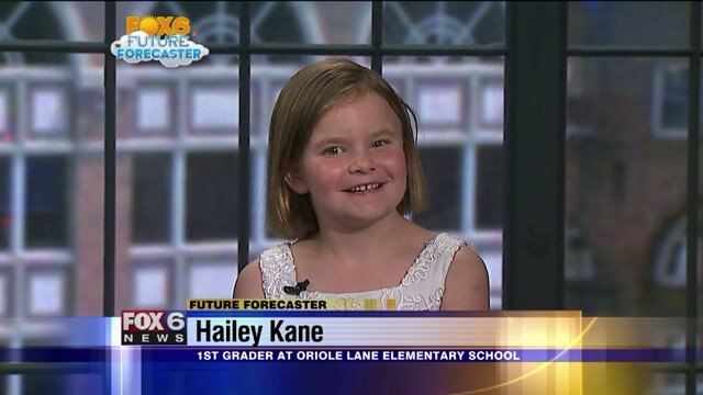Hailey Kane helps Meteorologist Rob Haswell with the weather