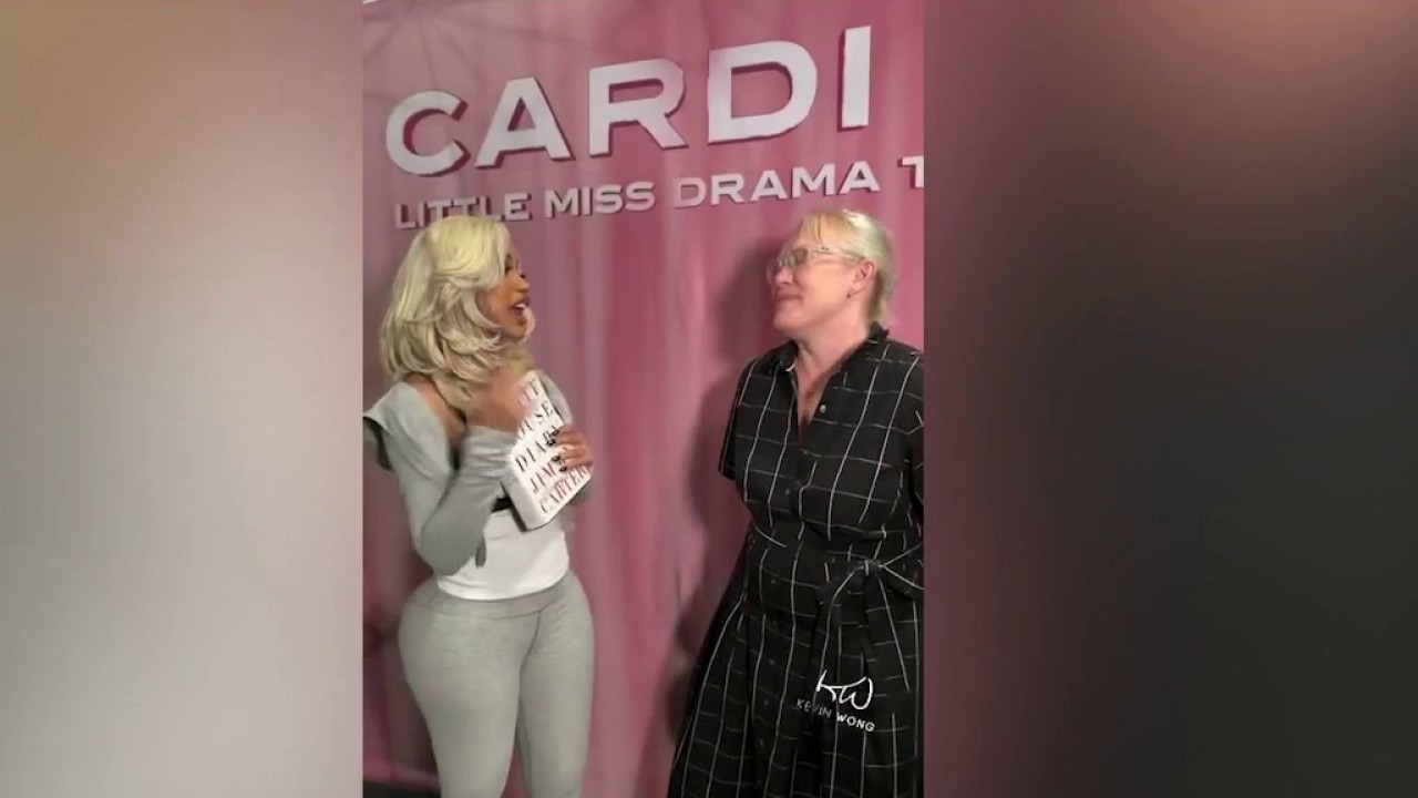 Amy Carter presents Cardi B with book